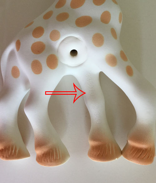 La jirafa sophie con una flecha indicando el número que aparece en una pierna el cuál es único